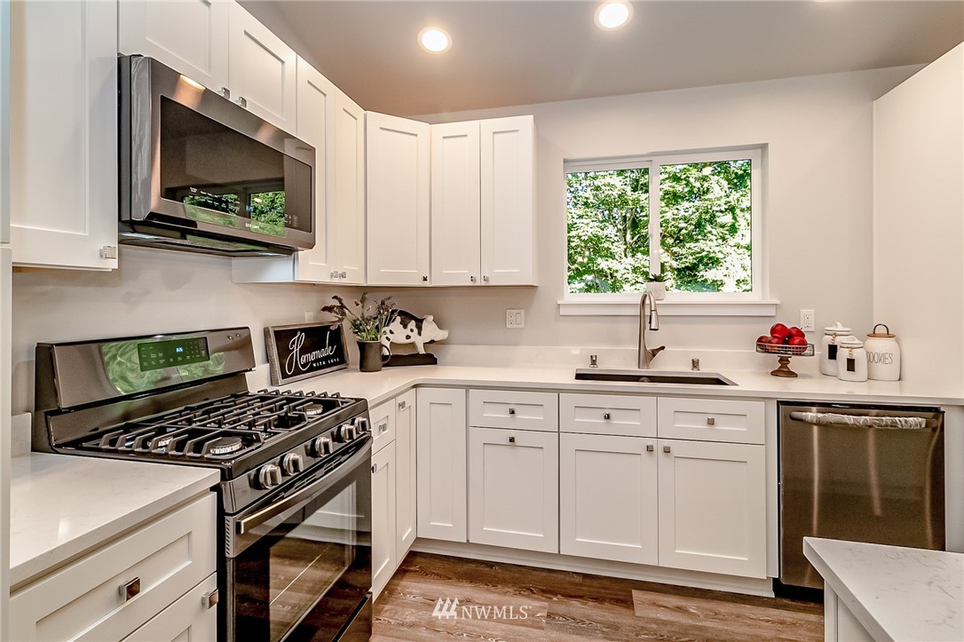17702 30th Drive Southeast Bothell, WA 98012 - Photo 4 of 17 a kitchen with stainless steel appliances white cabinets and a stove top oven