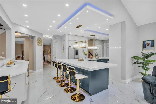 a kitchen with kitchen island stainless steel appliances a sink and a living room view