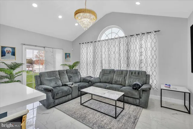 a living room with furniture a chandelier and a window