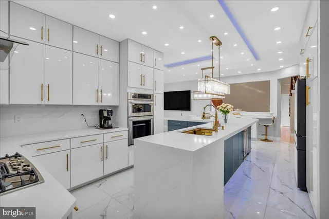 a kitchen with stainless steel appliances kitchen island granite countertop a sink and a refrigerator