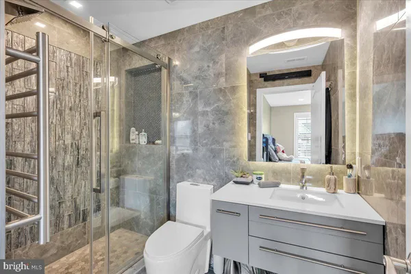 a bathroom with a sink a toilet and shower