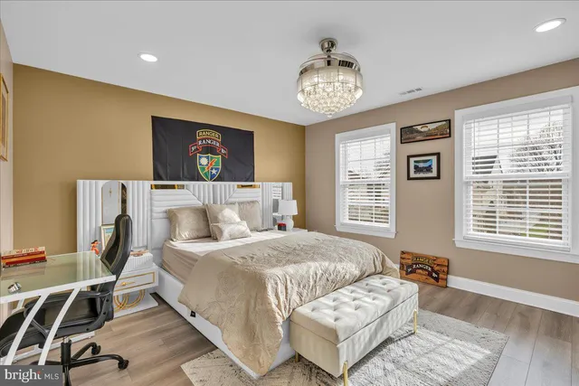 a bedroom with a bed and a desk with wooden floor