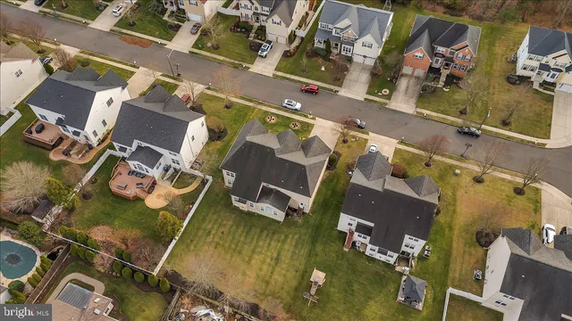 an aerial view of residential houses with outdoor space and parking