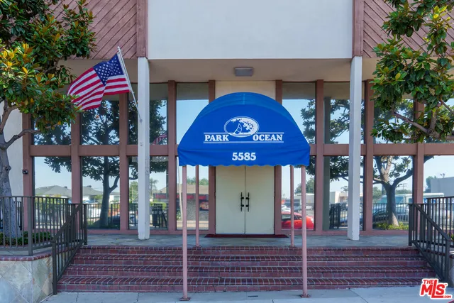 a view of a brick building with a red door and a large window