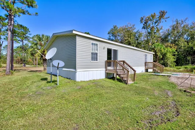 a view of a house with backyard and a garden