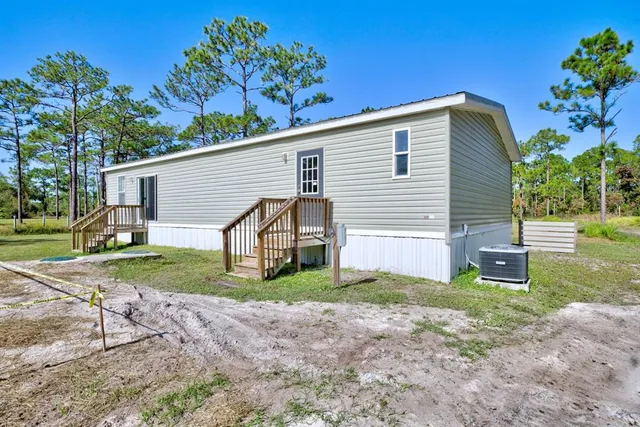 a view of a house with a yard and wooden fence