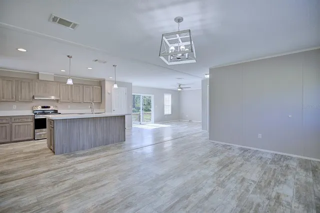 a view of kitchen with kitchen island and stainless steel appliances