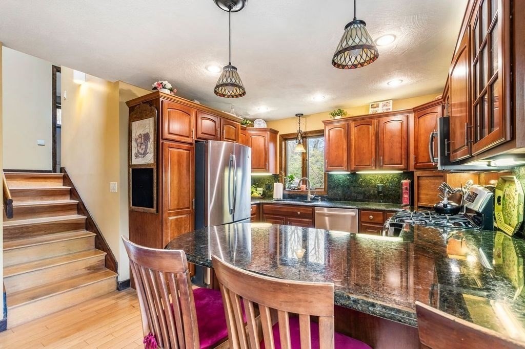 54 Acropolis Road Lowell, MA 01854 - Photo 6 of 35 a view of a livingroom with furniture staircase and kitchen view