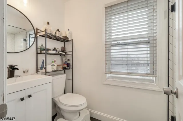 a bathroom with a toilet a sink and a mirror