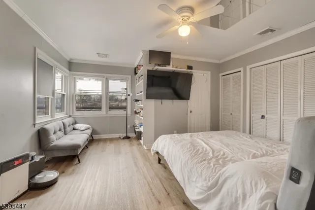 a spacious bedroom with a bed and a flat screen tv