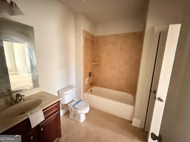 a bathroom with a bathtub toilet sink and mirror