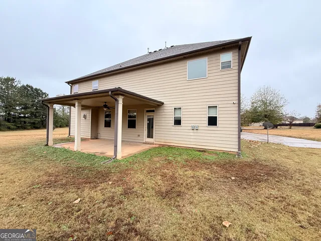a view of a house with backyard and trees