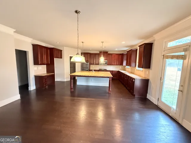 a living room with stainless steel appliances granite countertop furniture wooden floor and a view of kitchen