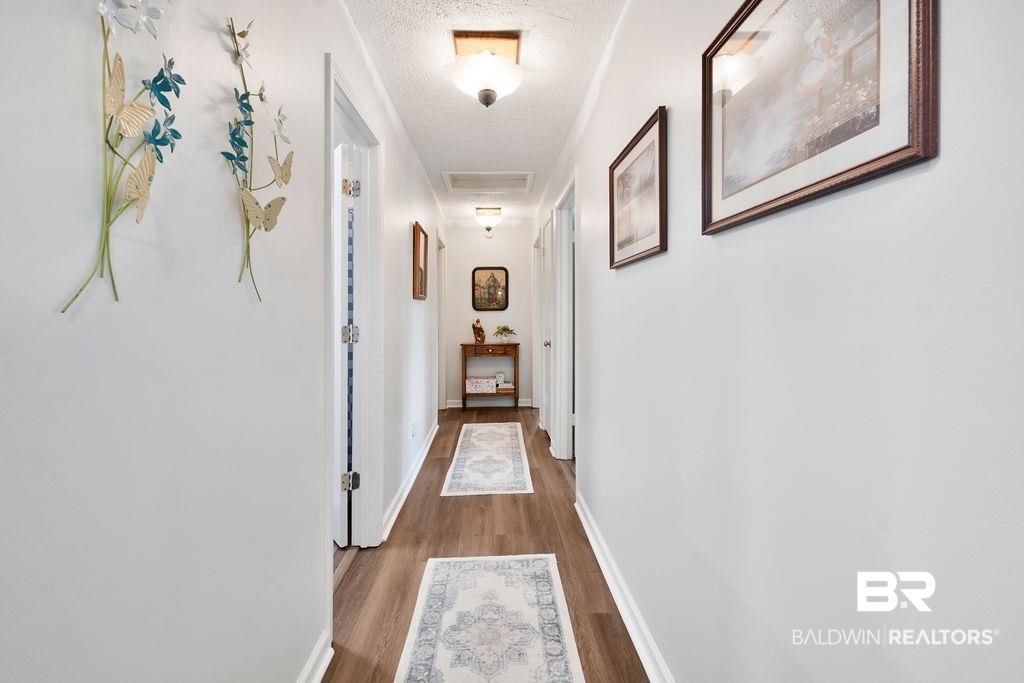 11901 Old Moffat Road Wilmer, AL 36587 - Photo 12 of 39 Corridor featuring a textured ceiling and dark wood finished floors