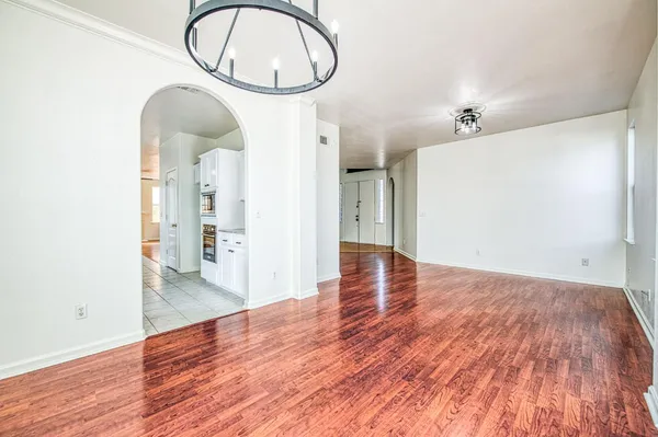 an empty room with a ceiling fan and windows