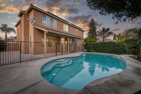 a dining room with wooden floor a chandelier a wooden table and chairs