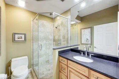 a bathroom with a granite countertop sink toilet and shower