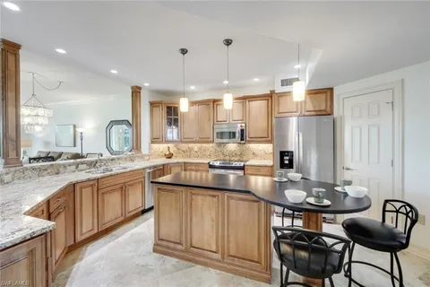 a kitchen with center island table and chairs