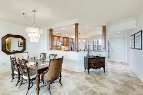 a dining room with chandelier and wooden floor