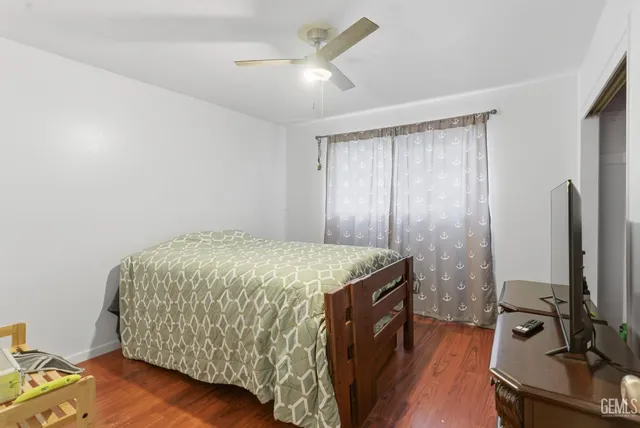 a bedroom with a bed and a flat tv screen on the dresser