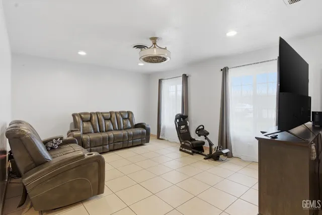 a living room with furniture a flat screen tv and a window