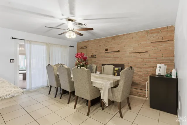 a dining room with furniture and chandelier fan