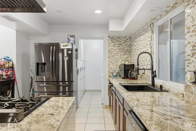 a kitchen with kitchen island granite countertop a sink and a stove