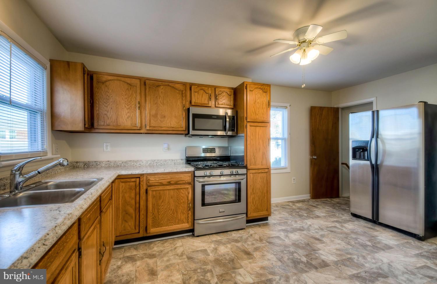 4202 Belle Grove Road Baltimore, MD 21225 - Photo 11 of 31 a kitchen with stainless steel appliances granite countertop a sink a stove a refrigerator cabinets and a sink