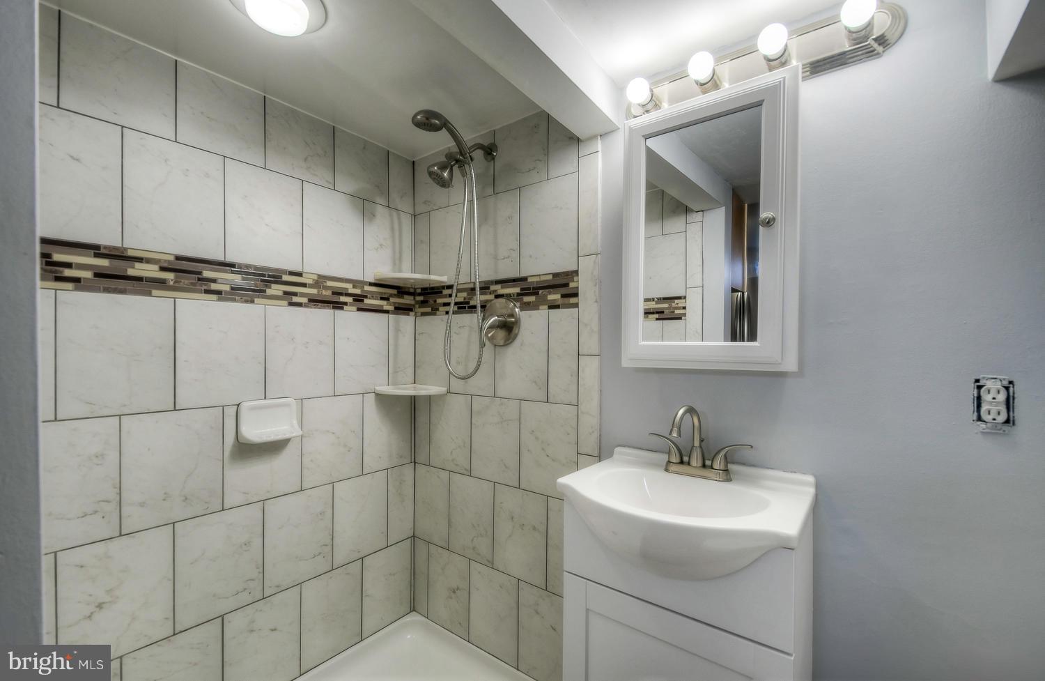 4202 Belle Grove Road Baltimore, MD 21225 - Photo 25 of 31 a bathroom with a sink shower and a mirror
