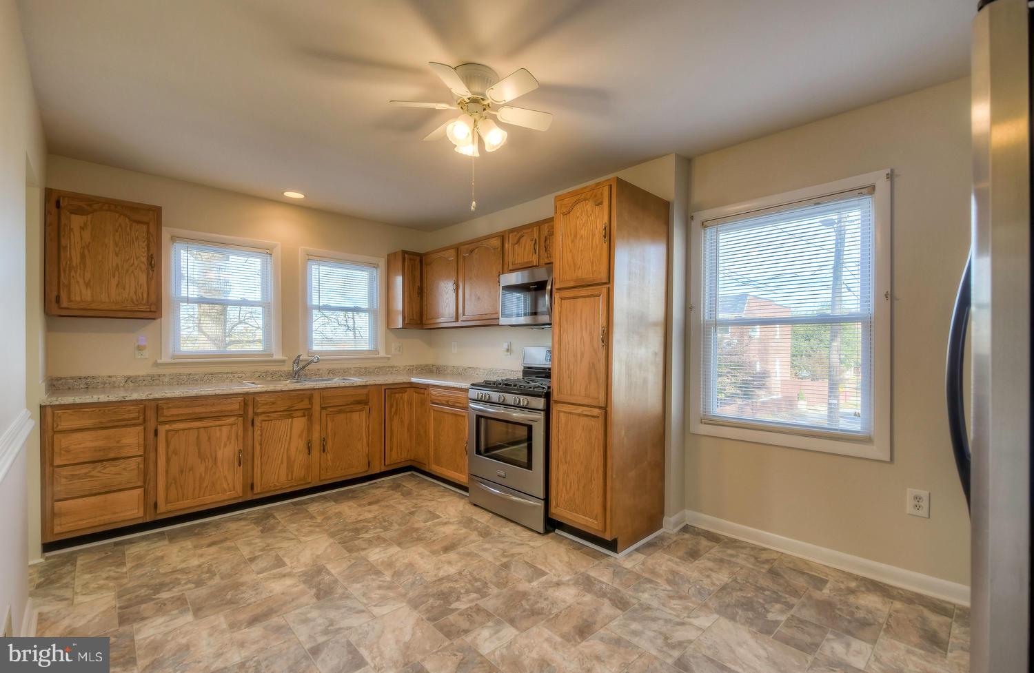 4202 Belle Grove Road Baltimore, MD 21225 - Photo 9 of 31 a kitchen with stainless steel appliances granite countertop a refrigerator a sink dishwasher a dining table and chairs with wooden floor