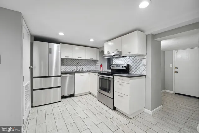 a kitchen with stainless steel appliances granite countertop a refrigerator sink and cabinets