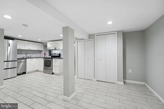 a view of kitchen refrigerator and cabinets