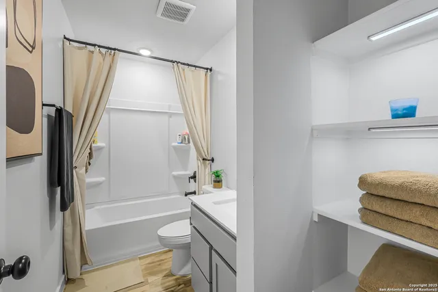a bathroom with a granite countertop sink toilet and shower