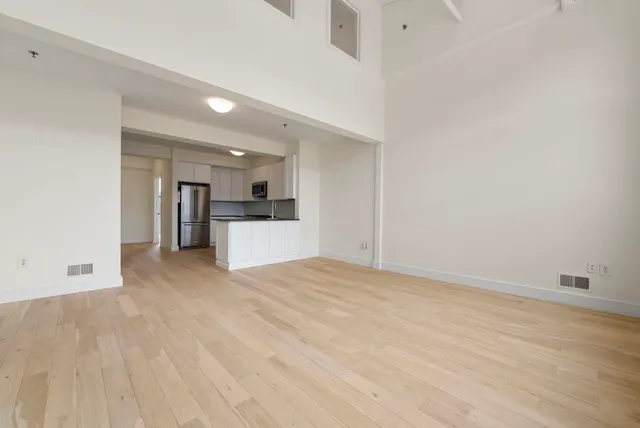 a kitchen with granite countertop a refrigerator and a stove top oven