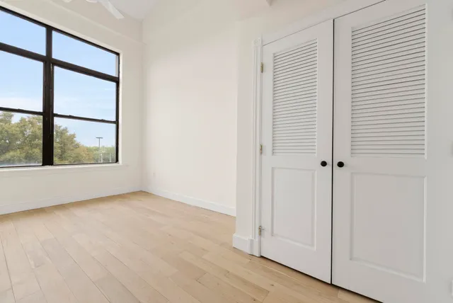 an empty room with wooden floor and windows