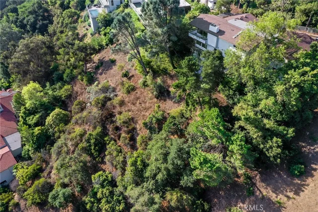 an aerial view of residential house with outdoor space and trees all around