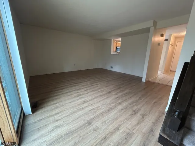 an empty room with wooden floor and entrance