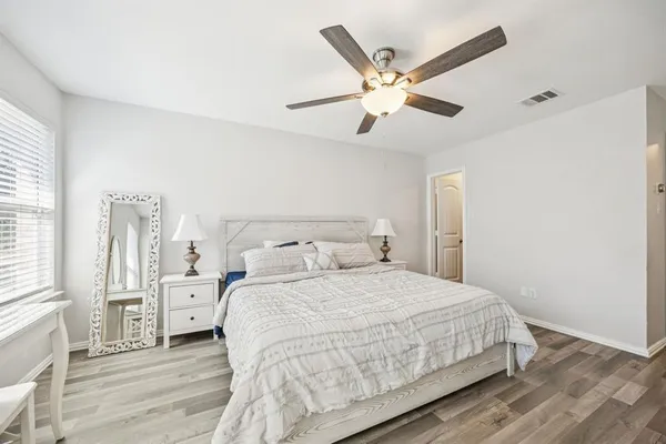 a bedroom with a large bed and a chandelier