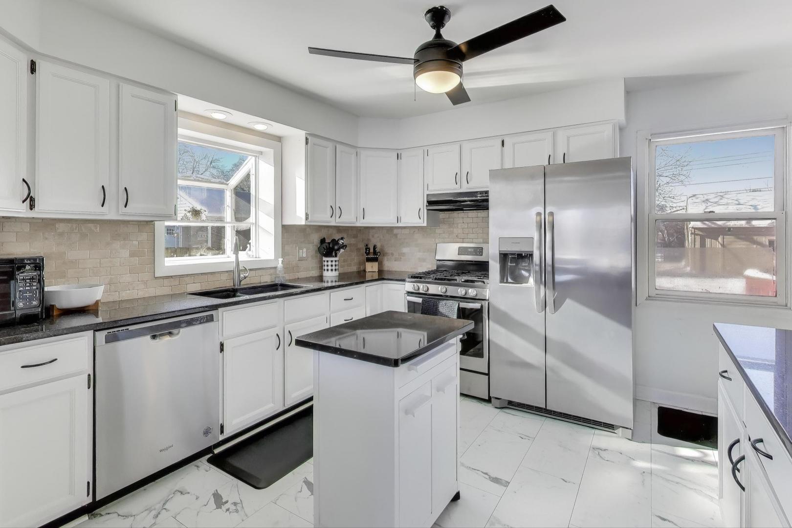 218 North School Street Mount Prospect, IL 60056 - Photo 8 of 30 a kitchen with granite countertop a sink stainless steel appliances and white cabinets