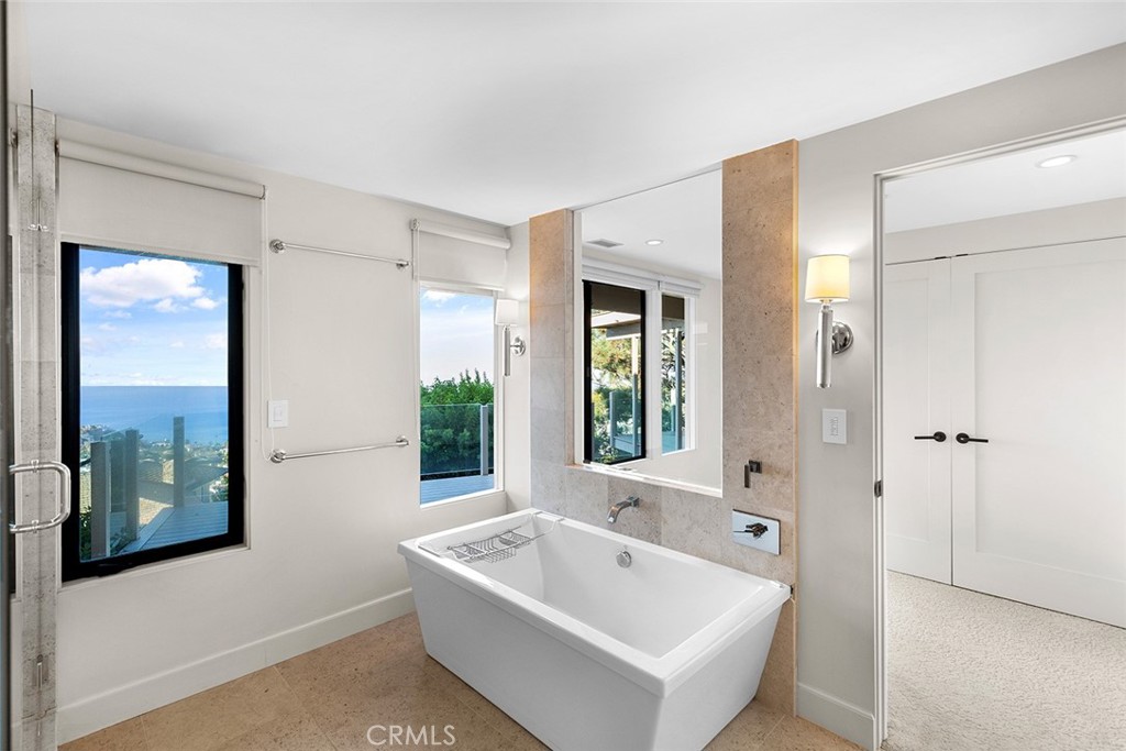 1503 Emerald Bay Laguna Beach, CA 92651 - Photo 14 of 32 a bathroom with a tub a sink and a large mirror
