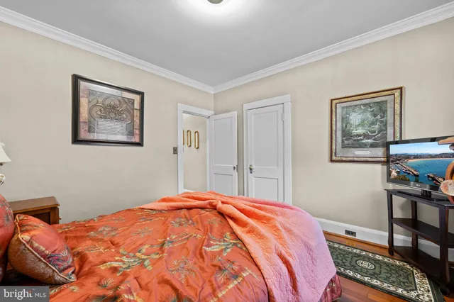 a bedroom with a bed and a lamp on dresser