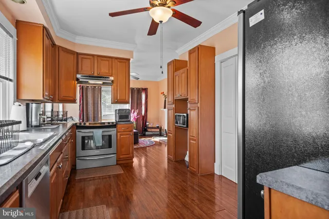 a kitchen with stainless steel appliances granite countertop a stove refrigerator and a dining table