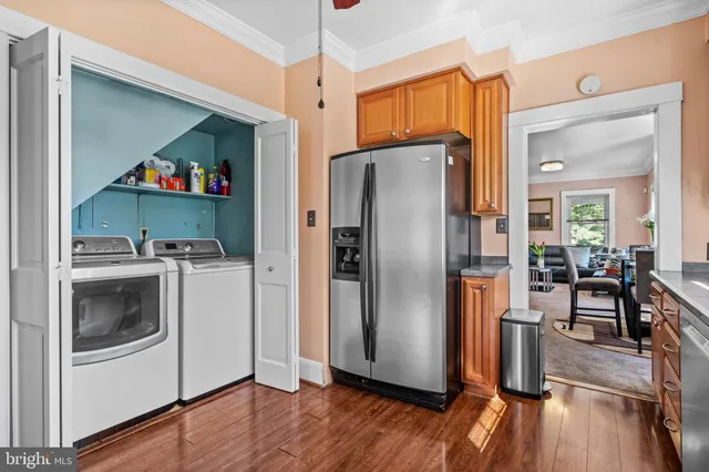 a kitchen with stainless steel appliances a refrigerator and wooden floor