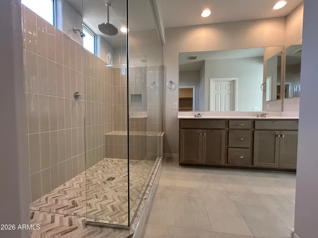 a spacious bathroom with a shower sink and mirror