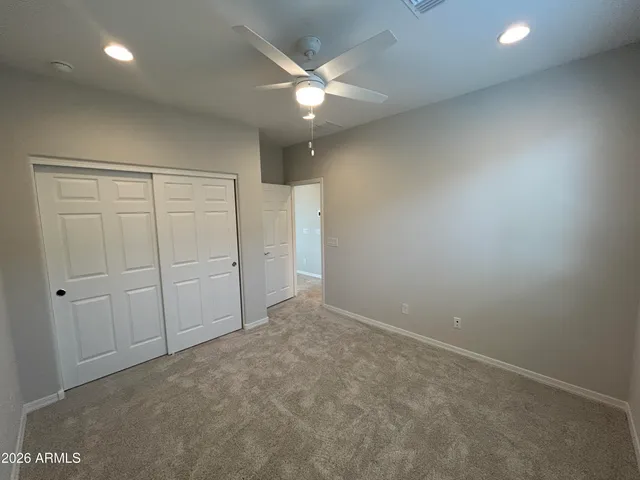 an empty room with closet and fan