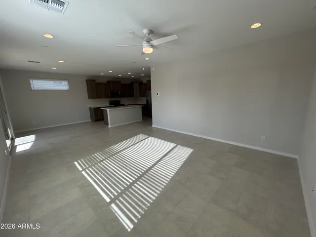en empty room with wooden floor and a ceiling fan