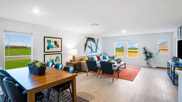 a living room with furniture kitchen view and a large window