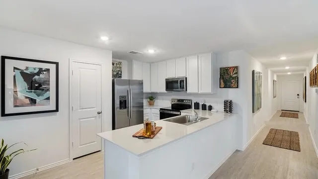 a kitchen with stainless steel appliances granite countertop a refrigerator and a stove top oven