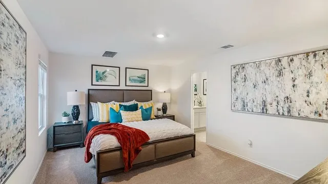 a bedroom with a bed and painting on the wall