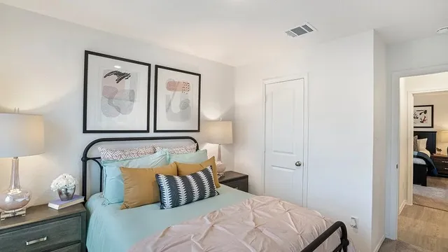 a bedroom with a bed and painting on the wall